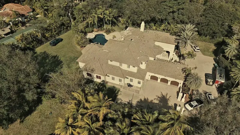 Front of a Pinecrest home with a finished tile roof, seen from above the driveway